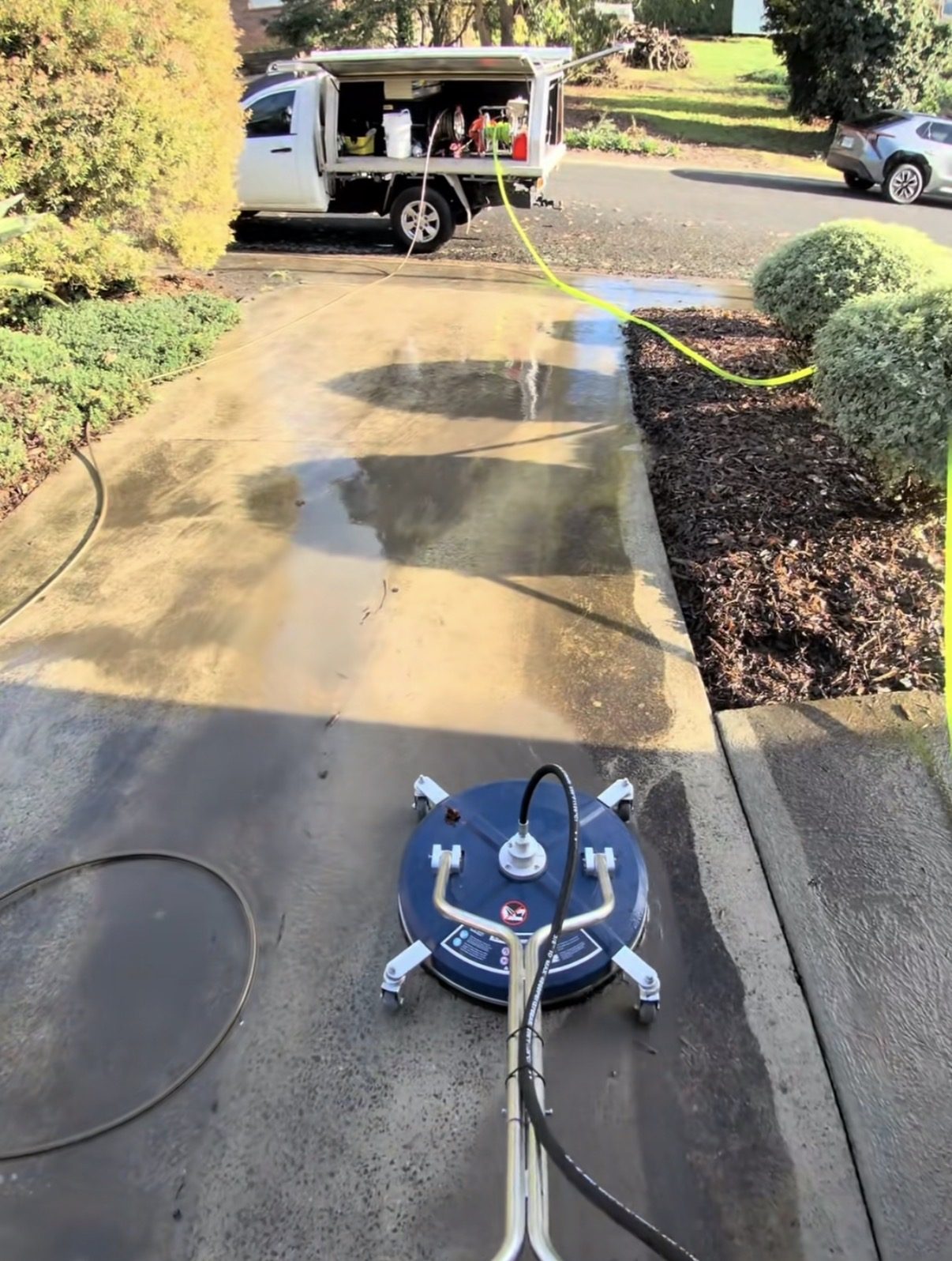 Surface cleaner pressure washing a concrete driveway